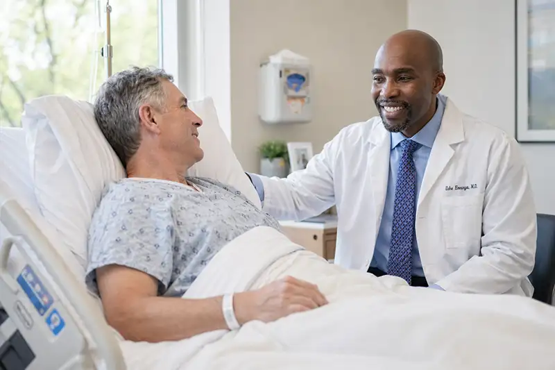 Patient recovering in hospital bed after spine surgery with physician check-in