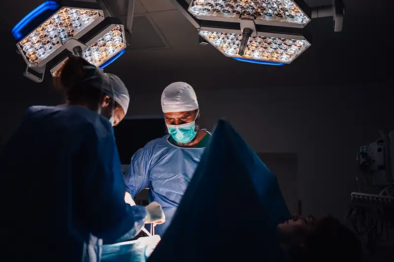 Surgical team performing spine procedure for persistent pain after prior surgery