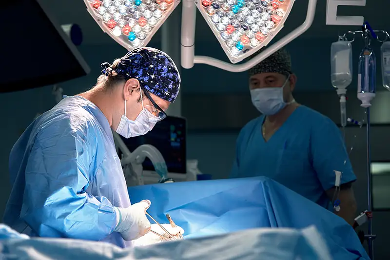 Surgeons performing orthopedic procedure on knee using precision instruments