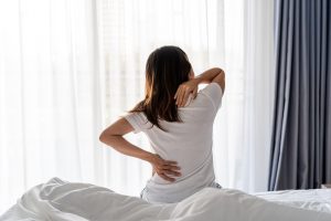 Woman waking up in the morning from nighttime chronic pain
