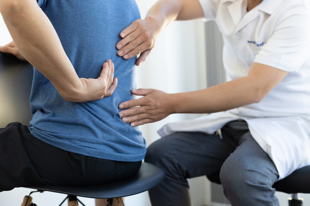 Patient showing pain doctor the sacroiliac joint and common pain areas in the low back